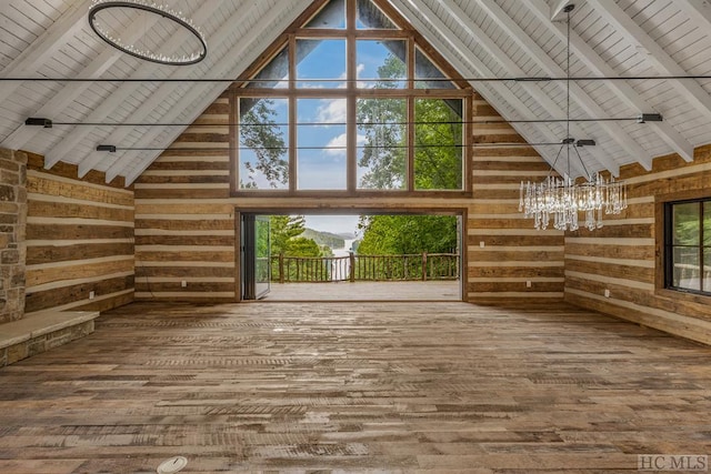 unfurnished living room with beamed ceiling, hardwood / wood-style floors, wood ceiling, and wooden walls