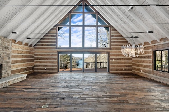 unfurnished living room with dark hardwood / wood-style flooring, wood ceiling, wooden walls, and beamed ceiling