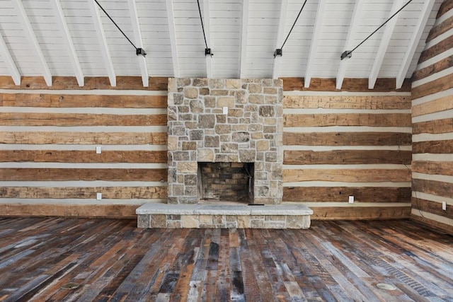 unfurnished living room featuring vaulted ceiling with beams, a fireplace, hardwood / wood-style floors, and wood walls