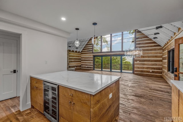 kitchen with lofted ceiling, beverage cooler, hanging light fixtures, dark wood-type flooring, and an inviting chandelier