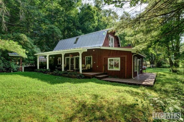 rear view of house with a wooden deck and a yard