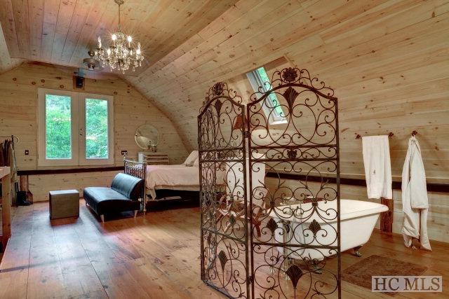 bedroom with hardwood / wood-style floors, lofted ceiling, wooden walls, and wooden ceiling