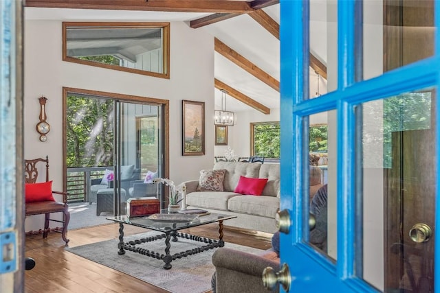 sunroom / solarium with lofted ceiling with beams and a chandelier