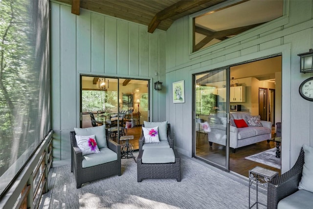 sunroom / solarium featuring lofted ceiling with beams