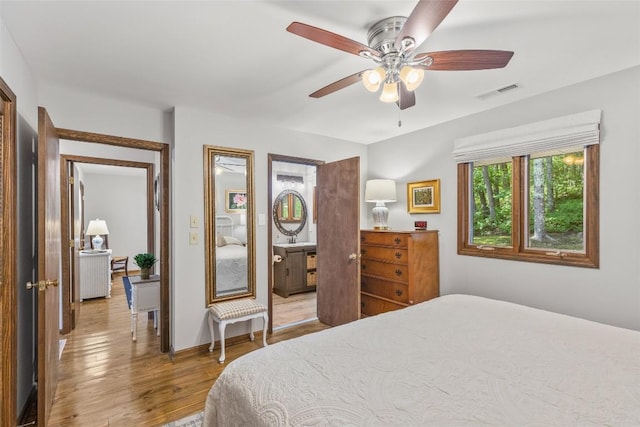 bedroom with a ceiling fan, visible vents, wood-type flooring, and baseboards