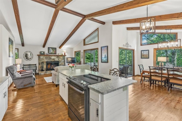 kitchen with light stone counters, white cabinetry, light wood-type flooring, and electric range oven