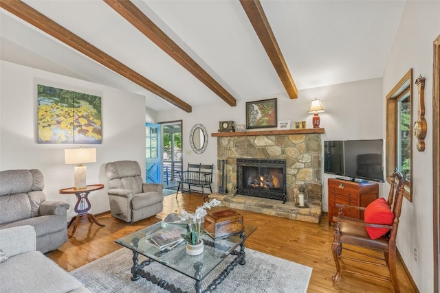 living room with a fireplace, beamed ceiling, wood finished floors, and baseboards