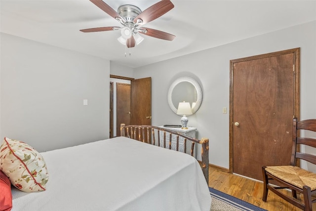 bedroom with wood finished floors, baseboards, and ceiling fan