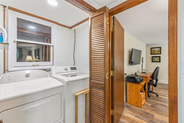 laundry area featuring ornamental molding, washing machine and dryer, light wood finished floors, baseboards, and laundry area