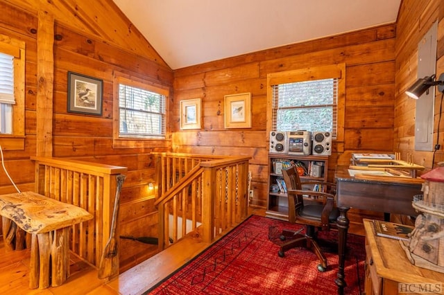 office area featuring vaulted ceiling and wooden walls