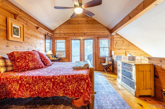 bedroom with vaulted ceiling, light hardwood / wood-style flooring, cooling unit, wooden walls, and access to exterior