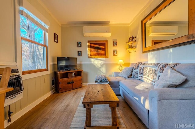 living room featuring crown molding, hardwood / wood-style floors, and an AC wall unit