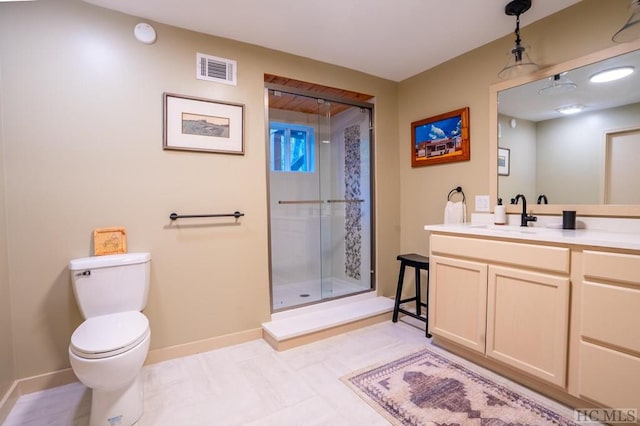 bathroom featuring vanity, toilet, and a shower with shower door