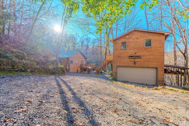 view of home's exterior with a garage and a deck