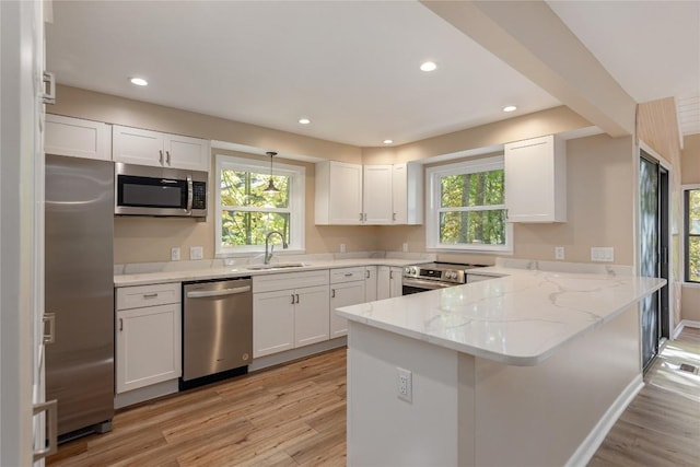 19 Indian Falls Way, Lake Toxaway, NC 28747 - kitchen with light wood-type flooring, white cabinetry, light stone counters, a sink, and stainless steel appliances