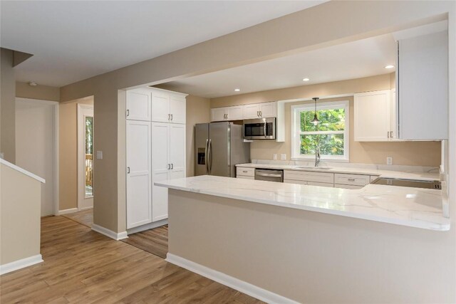 19 Indian Falls Way, Lake Toxaway, NC 28747 - kitchen featuring appliances with stainless steel finishes, light countertops, a sink, a peninsula, and white cabinetry