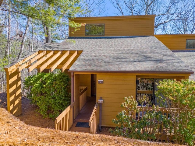 exterior space featuring roof with shingles