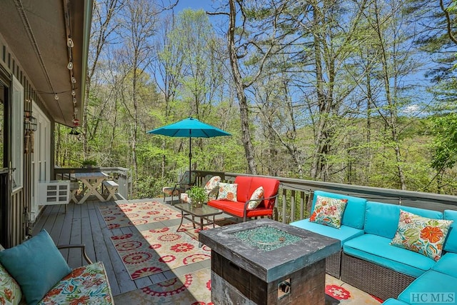 wooden deck featuring an outdoor living space with a fire pit