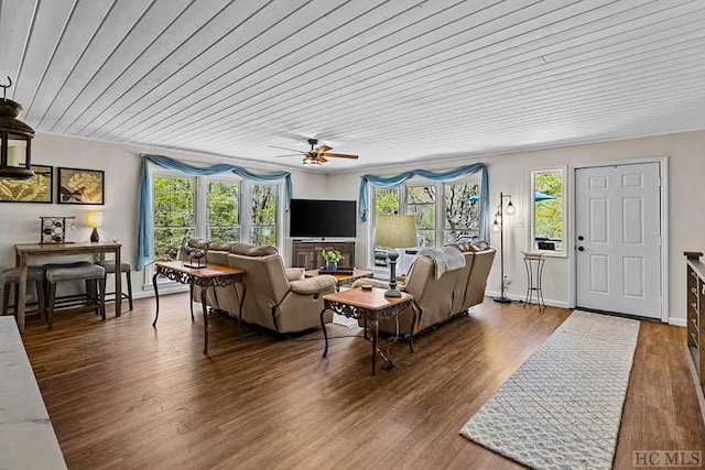 living room featuring plenty of natural light, dark wood-type flooring, and wooden ceiling