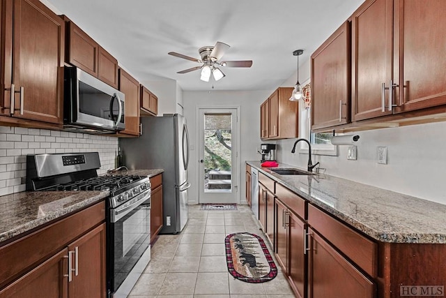 kitchen featuring sink, hanging light fixtures, light tile patterned floors, ceiling fan, and stainless steel appliances