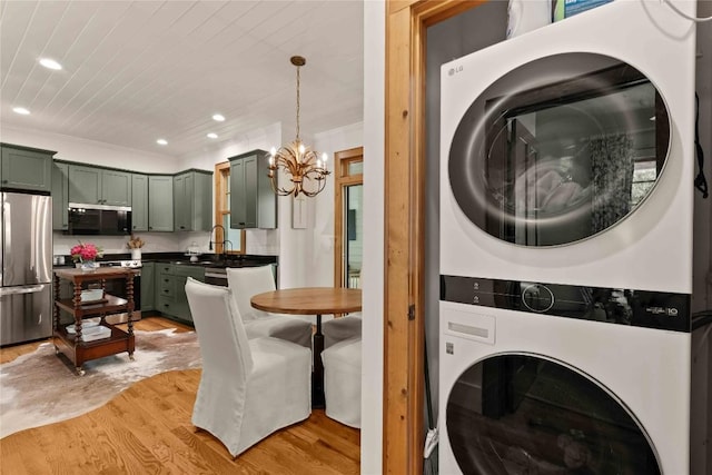 60 Glassy Vw, Cashiers, NC 28717 - laundry area featuring stacked washer and clothes dryer, light wood-style floors, a chandelier, recessed lighting, and ornamental molding