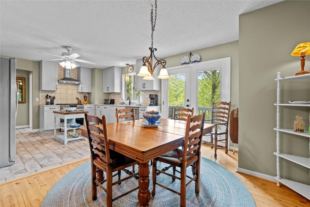 233 Strawberry Hill Rd, Cullowhee, NC 28723 - dining space with french doors, a ceiling fan, a textured ceiling, baseboards, and light wood-type flooring