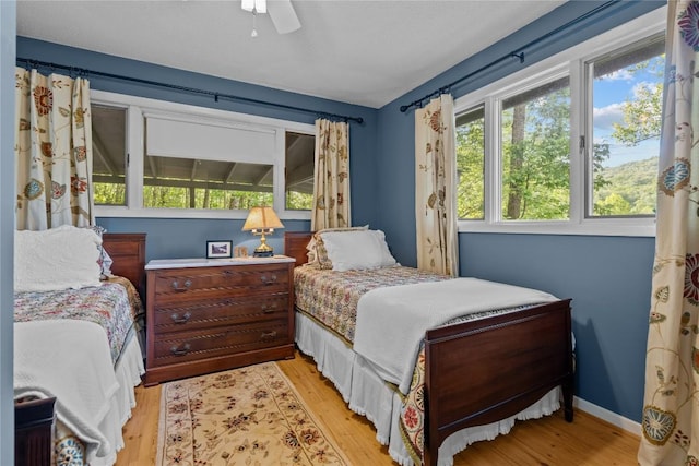 233 Strawberry Hill Rd, Cullowhee, NC 28723 - bedroom with light wood-style flooring, a ceiling fan, and baseboards