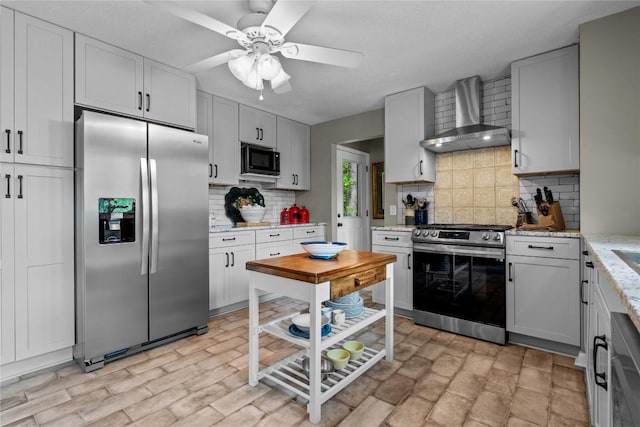 233 Strawberry Hill Rd, Cullowhee, NC 28723 - kitchen featuring stainless steel appliances, wall chimney exhaust hood, tasteful backsplash, a ceiling fan, and light stone countertops