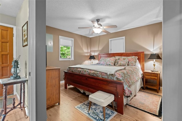 233 Strawberry Hill Rd, Cullowhee, NC 28723 - bedroom featuring light wood finished floors, a textured ceiling, baseboards, and ceiling fan