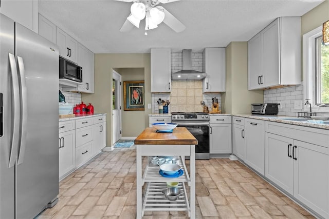233 Strawberry Hill Rd, Cullowhee, NC 28723 - kitchen featuring stainless steel appliances, wall chimney exhaust hood, decorative backsplash, and a ceiling fan