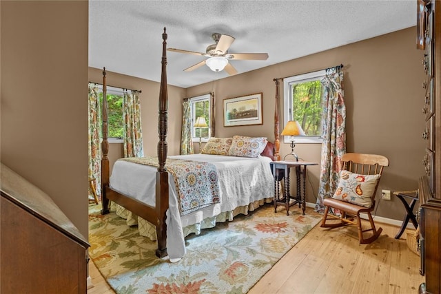 233 Strawberry Hill Rd, Cullowhee, NC 28723 - bedroom with wood-type flooring, baseboards, a textured ceiling, and a ceiling fan