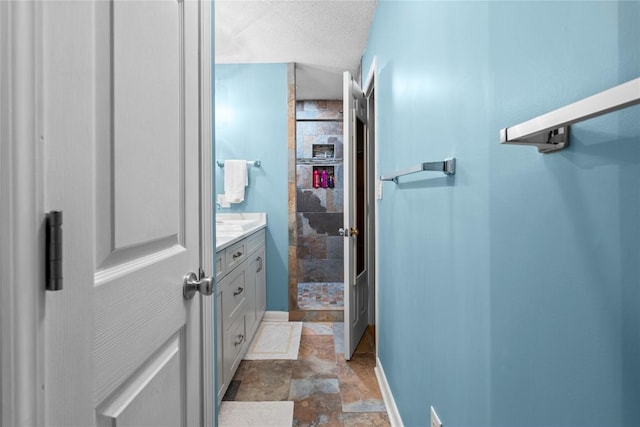 233 Strawberry Hill Rd, Cullowhee, NC 28723 - full bathroom featuring stone finish floors, vanity, baseboards, and a tile shower