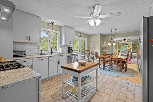 233 Strawberry Hill Rd, Cullowhee, NC 28723 - kitchen with stainless steel appliances, a sink, ceiling fan, decorative backsplash, and decorative light fixtures