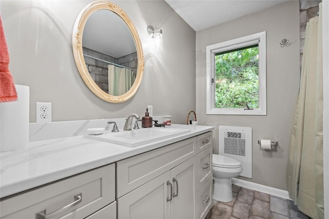 233 Strawberry Hill Rd, Cullowhee, NC 28723 - bathroom with vanity, toilet, stone finish floors, baseboards, and radiator heating unit