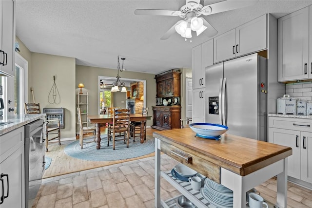 233 Strawberry Hill Rd, Cullowhee, NC 28723 - kitchen featuring stainless steel appliances, a ceiling fan, light stone countertops, decorative backsplash, and decorative light fixtures