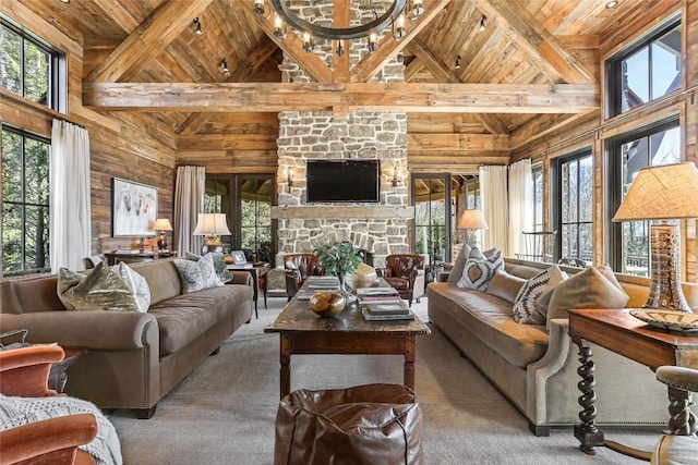 196 Stove Pipe Ct, Cashiers, NC 28717 - carpeted living area featuring wood ceiling with exposed beams, high vaulted ceiling, a stone fireplace, and wooden walls