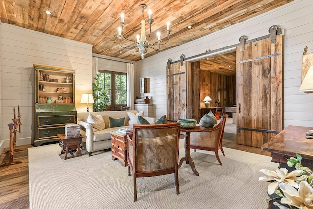 196 Stove Pipe Ct, Cashiers, NC 28717 - living area with wood walls, wood finished floors, wooden ceiling, a barn door, and a chandelier