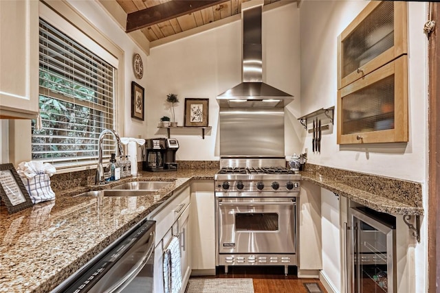 kitchen with a sink, premium range, wall chimney range hood, dishwashing machine, and light stone counters