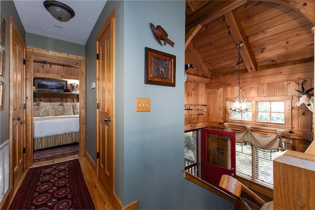 8 Par Path, Cashiers, NC 28717 - hall featuring a chandelier, wood finished floors, an upstairs landing, wood walls, and wooden ceiling