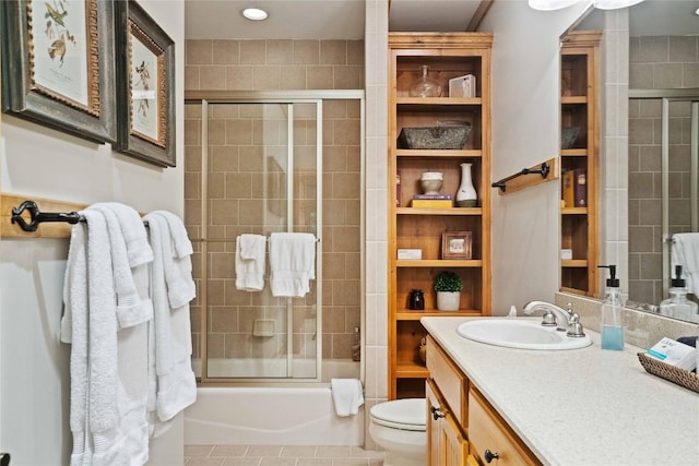 full bathroom featuring enclosed tub / shower combo, vanity, toilet, and tile patterned floors