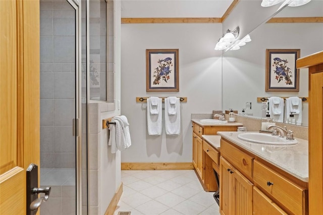 bathroom with a stall shower, vanity, baseboards, and tile patterned floors