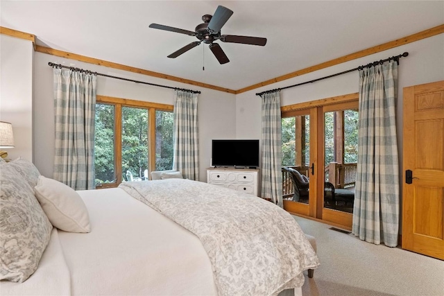 carpeted bedroom with a ceiling fan, multiple windows, visible vents, and access to exterior