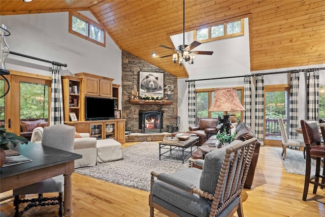 living room with high vaulted ceiling, light wood-type flooring, a fireplace, and ceiling fan