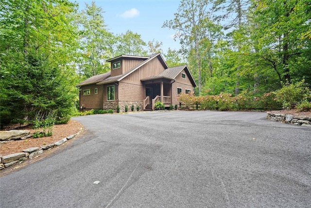 view of front facade featuring stone siding and aphalt driveway