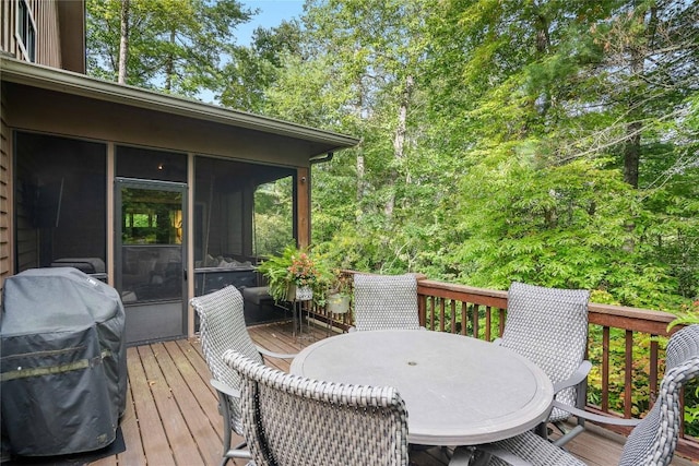 wooden terrace with a sunroom, outdoor dining area, and area for grilling