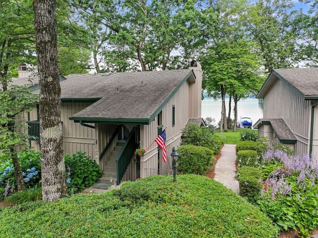 28 Toxaway Pt Unit 7, Lake Toxaway, NC 28747 - view of front of property featuring a shingled roof, a chimney, and a water view