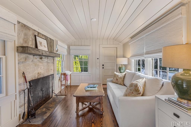 living room with lofted ceiling, dark wood-type flooring, wooden walls, a fireplace, and wooden ceiling