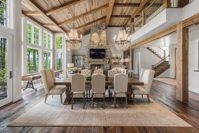 547 Burl Ln, Cashiers, NC 28717 - dining room with a chandelier, wooden ceiling with exposed beams, high vaulted ceiling, hardwood / wood-style flooring, and a stone fireplace