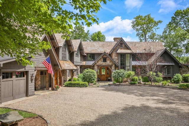 547 Burl Ln, Cashiers, NC 28717 - view of front of property featuring stone siding, gravel driveway, a chimney, and a garage