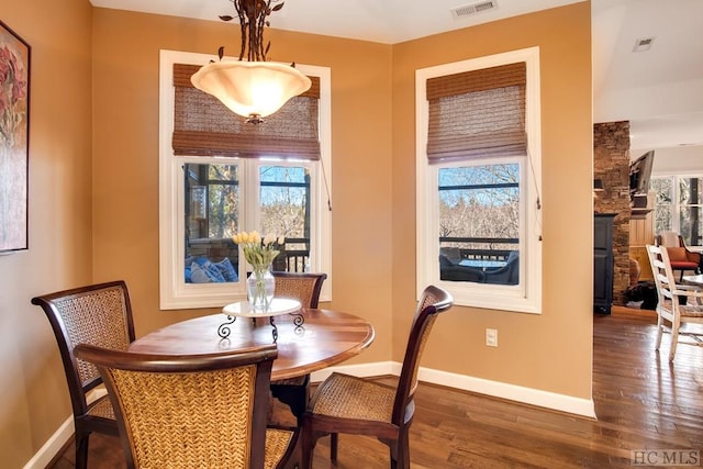 dining space with a fireplace and dark hardwood / wood-style flooring